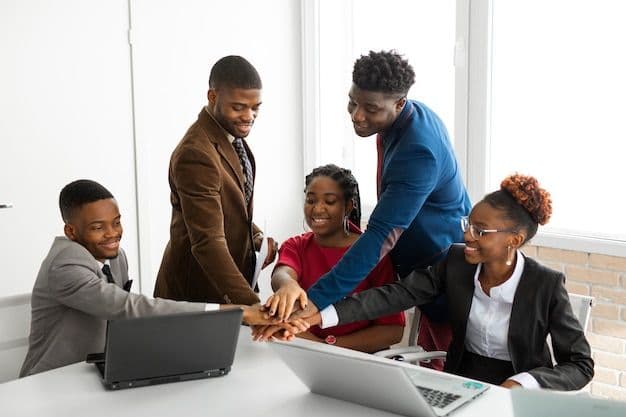 Équipe tech africaine collaborant autour d'un ordinateur dans un bureau moderne